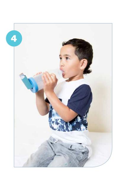 Photo of a child holding a spacer with an inhaler attached to the end