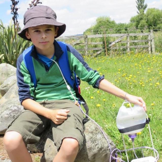 Photo of Alex who is tube feeding while taking a break from his day walk.