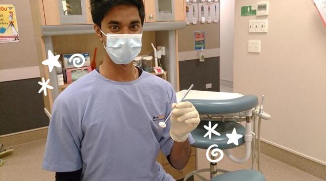 Dental therapist in a mask and gown 