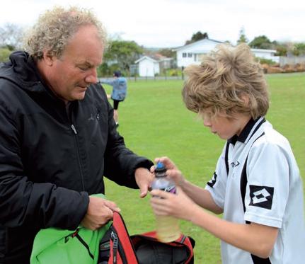 A dad and a teenage boy at a soccer game