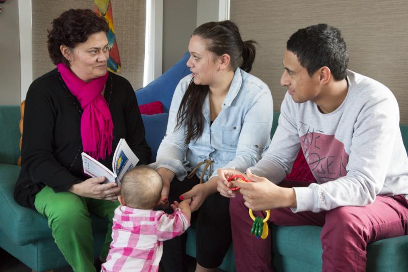 Tamariki Ora nurse sitting talking to a mum and her partner with their baby