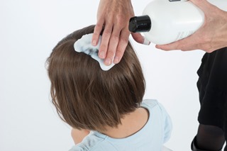 Applying hair conditioner to a child's hair