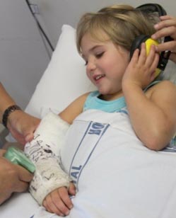 Photo of young girl having her arm plaster cast removed