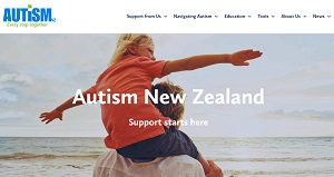 Autism NZ homepage showing the Autism NZ logo, information and a photo of a child on their parent's shoulders at a beach