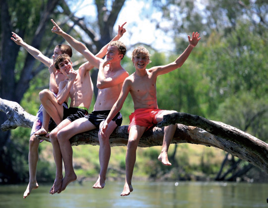 A group of teenage boys sitting on a log