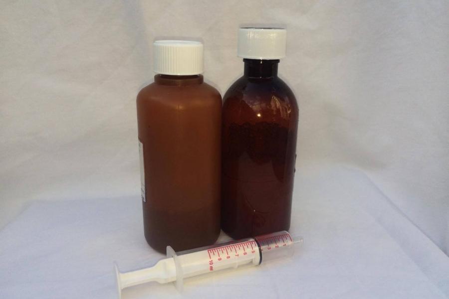 Medicine bottles with safety lids and a measuring syringe in front