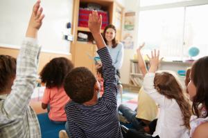 Classroom with children raising their hand to ask a question