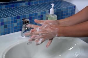 Hands being washed under a tap
