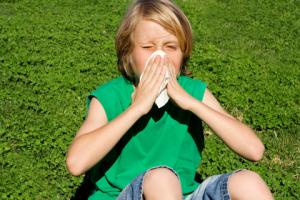 Child with allergy blowing nose