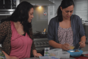 Two mothers preparing baby food together in the kitchen